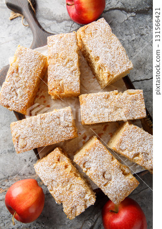 Applesauce cake is a dessert cake prepared using apple sauce, flour and sugar close-up on wooden board. Vertical top view 131566421
