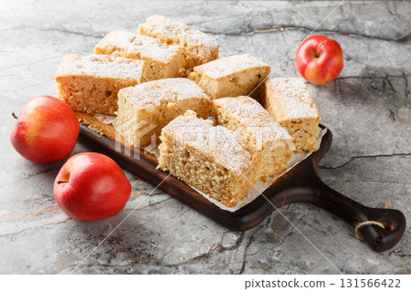 Applesauce cake with warm spices like cloves, ginger, and cinnamon close-up on a wooden board. Horizontal 131566422