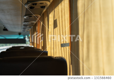 The curtains inside the bus are filled with golden sunlight The curtains inside the bus are filled with golden sunlight 131566460