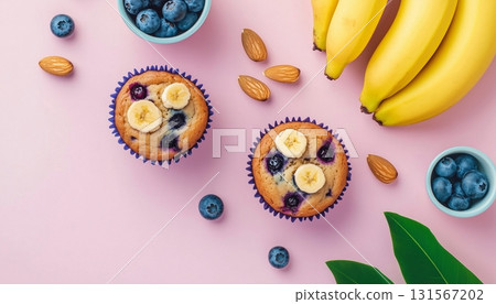 Banana fruit slice, blueberry almond topping on muffin cake cup on pink background Banana fruit slice, blueberry almond topping on muffin cake cup on pink background 131567202
