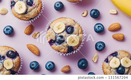 Banana fruit slice, blueberry almond topping on muffin cake cup on pink background Banana fruit slice, blueberry almond topping on muffin cake cup on pink background 131567204