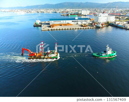 Aerial view of a barge and tugboat returning from a construction site at Hakodate Port in Hakodate, Hokkaido in autumn 131567409