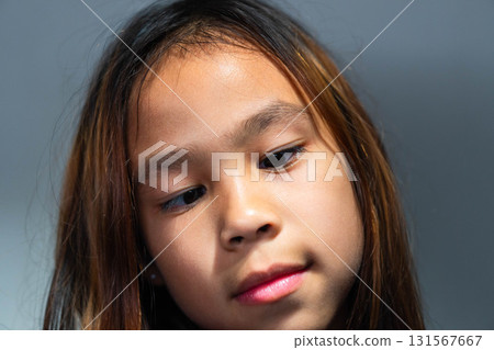 Close-up Portrait of a Thoughtful Asian Girl Looking Straight at the Camera 131567667