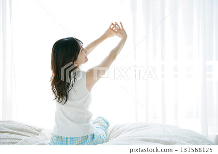 坐和舒展在床上的婦女 131568125