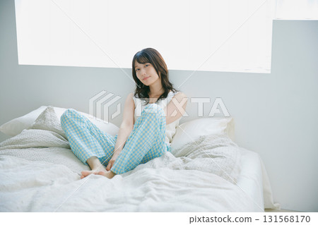 一個女人坐在床上 131568170