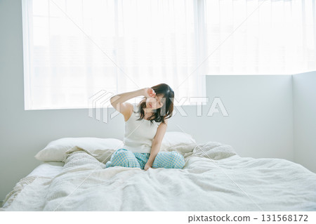 A woman sitting on a bed A woman sitting on a bed 131568172