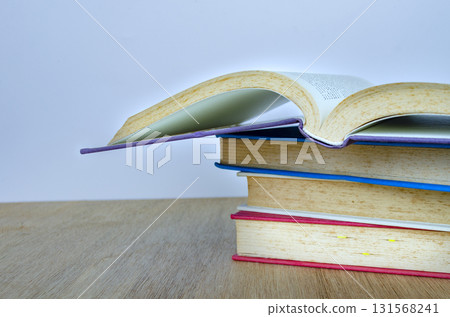 A neatly stacked group of books on a wooden table with customizable space for text. Growth concept. 131568241