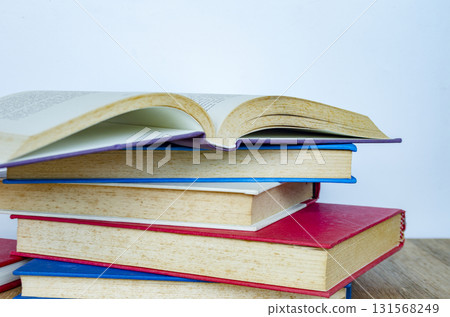 A collection of books with pages curling slightly upward arranged artistically to symbolize creative reading. A collection of books with pages curling slightly upward arranged artistically to symbolize creative reading. 131568249