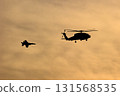 Fighter planes and helicopters flying in the sunset sky 131568535