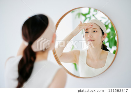 一個女人在鏡子裡檢查她的皮膚狀況 131568847