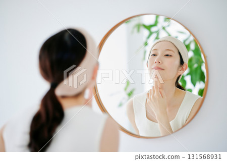 一個女人在鏡子裡檢查她的皮膚狀況 一個女人在鏡子裡檢查她的皮膚狀況 131568931