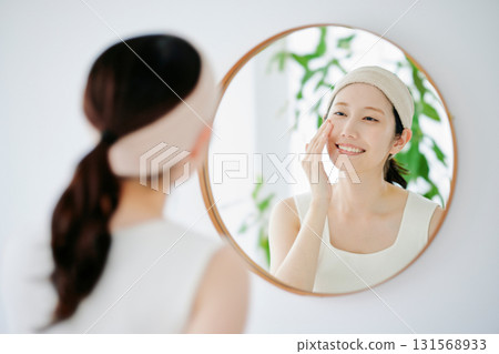 一個女人在鏡子裡檢查她的皮膚狀況 一個女人在鏡子裡檢查她的皮膚狀況 131568933