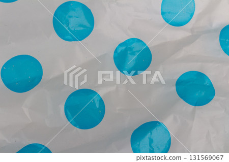 Wrinkled opaque plastic background with blue dotted pattern textured plastic surface close-up 131569067