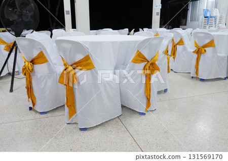 A row of decorated chairs with golden color ribbon at temple. A row of decorated chairs with golden color ribbon at temple. 131569170