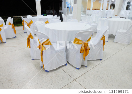 A row of decorated chairs with golden color ribbon at temple. A row of decorated chairs with golden color ribbon at temple. 131569171