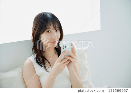A young woman operating a smartphone 131569967
