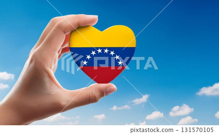 手舉的心形委內瑞拉國旗映襯在藍天下 手舉的心形委內瑞拉國旗映襯在藍天下 131570105