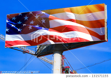 Large billboard with the USA american flag with blue sky behind it. Large billboard with the USA american flag with blue sky behind it. 131571155