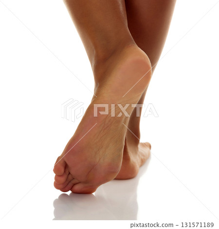 Closeup shot of tanned female feet, isolated on white background 131571189