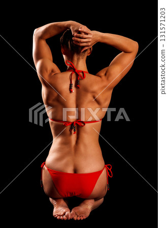 Sexy sports woman in red bikini posing against black background Sexy sports woman in red bikini posing against black background 131571203