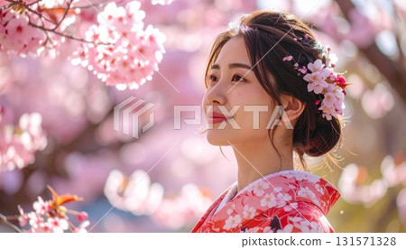 A young woman in a kimono with illuminated cherry blossoms in the background 131571328