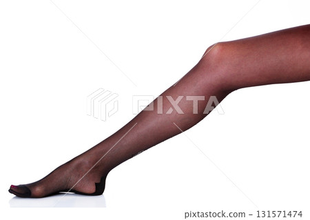 Female leg in black stockings, isolated on white background Female leg in black stockings, isolated on white background 131571474