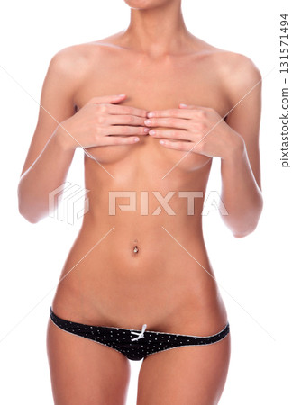 Young slim woman covers her breasts with her fingers, isolated on white background 131571494