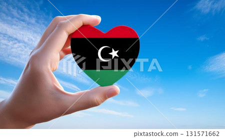 Libyan flag heart shape and blue sky held by hand 131571662
