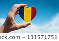 Romanian flag heart shape and blue sky held by hand 131571751