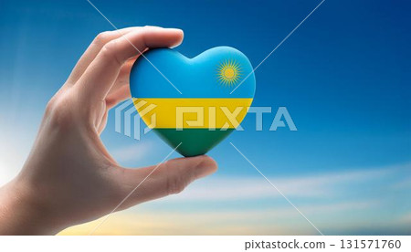 Heart shaped Rwandan flag held by hand against blue sky 131571760