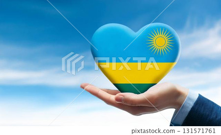 Heart shaped Rwandan flag held by hand against blue sky 131571761