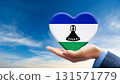 Lesotho flag heart and blue sky held by hand 131571779