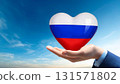 Hand holding a Russian flag heart and blue sky 131571802
