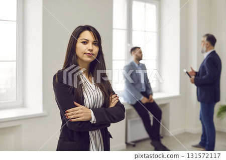 Young businesswoman or corporate worker standing with her arms crossed in the office 131572117