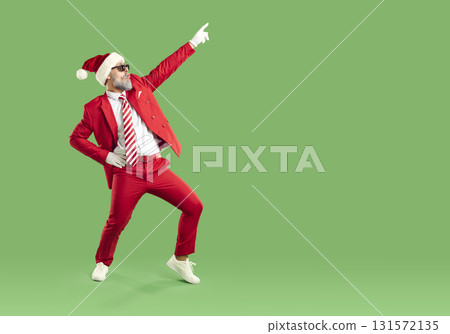 Full length portrait of amazed man wearing Santa style pointing index finger up on green background. Full length portrait of amazed man wearing Santa style pointing index finger up on green background. 131572135