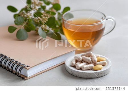 Omega-3 Capsules with Notebook and Cup of Tea 131572144