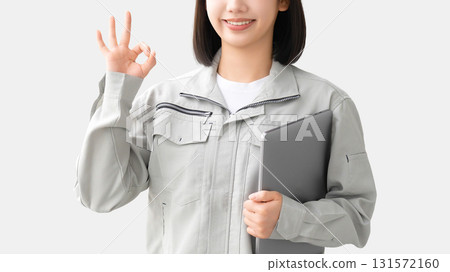 一位身穿工作服的年輕女子拿著筆記型電腦，擺出「OK」姿勢 131572160