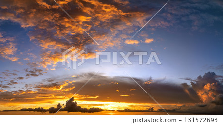Colorful sunset sky with setting sun behind vivid orange and yellow clouds Colorful sunset sky with setting sun behind vivid orange and yellow clouds 131572693