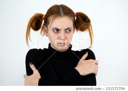Closeup portrait of a sad redhead teenage girl with childish hairstyle looking offended isolated on white backround. Closeup portrait of a sad redhead teenage girl with childish hairstyle looking offended isolated on white backround. 131572704