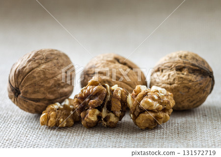 Close-up of walnuts, in wooden shell and kernels isolated on light copy space background. Healthy organic food concept. 131572719