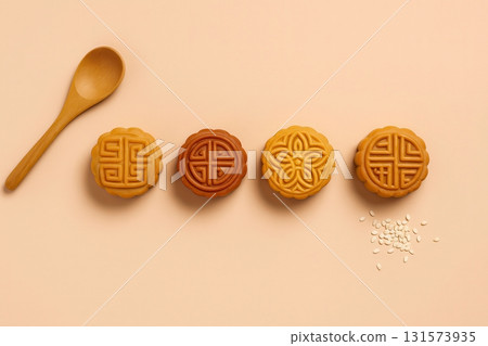 Mooncakes lined up with spoon and sesame on pastel surface 131573935