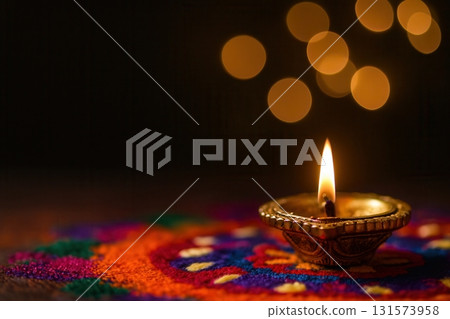 Golden Diya Lamp on Colorful Rangoli with Glowing Bokeh Lights 131573958