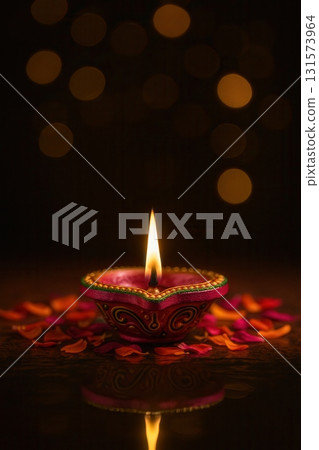 Decorative Diya with Burning Flame and Petals for Diwali Celebration 131573964