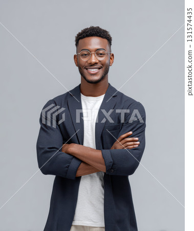 Confident young african businessman smiling. successful and professional black man in candid portrait with positive expression, standing isolated on gray background 131574435