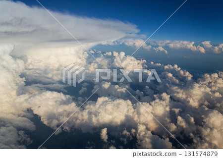 Sky with dramatic beautiful white fluffy clouds viewed from airplane, blue sky, aerial view, copy space, travel concept Sky with dramatic beautiful white fluffy clouds viewed from airplane, blue sky, aerial view, copy space, travel concept 131574879