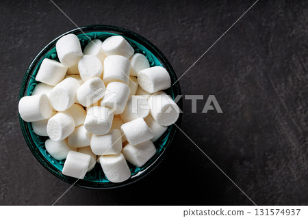 White Marshmallows in Turquoise Bowl on Dark Background Top View Copy Space 131574937