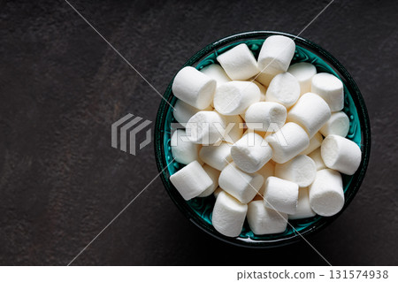 White Marshmallows in Turquoise Bowl on Dark Background Top View Copy Space 131574938
