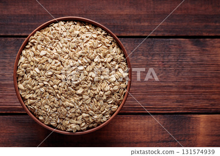 Raw Whole Oats in Ceramic Bowl on Dark Wood Background Top View Copy Space Raw Whole Oats in Ceramic Bowl on Dark Wood Background Top View Copy Space 131574939