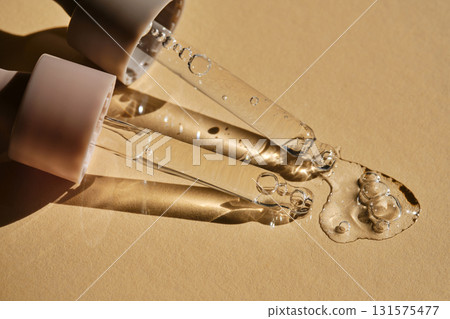Two pipettes with serum on a beige background. Two pipettes with serum on a beige background. 131575477