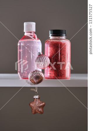 A large bottle of serum or tonic and bath salts with Christmas toys. The Christmas concept. 131575527
